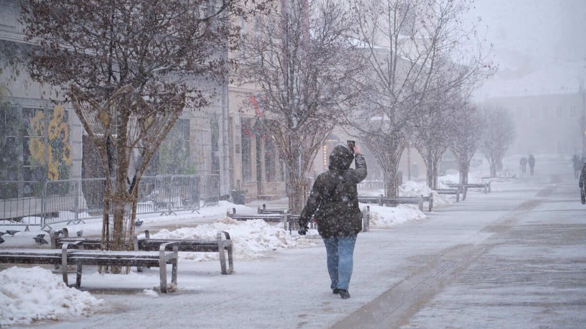 Kobieta fotografująca zjawisko intensywnego śniegu