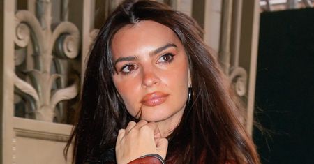 Emily Ratajkowski w kusym mundurku. Jednak uwagę skupia coś innego