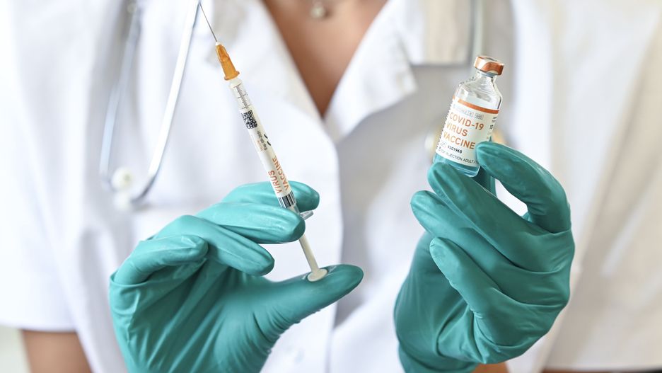 BRUSSELS, BELGIUM - JUNE 18 : In this illustration a doctor holds a syringe and a bottle labelled as the Covid-19 coronavirus vaccine. At least 8,000,202 cases of infection, including 435,176 deaths, were recorded in total, particularly in Europe, the continent most affected with 2,417,902 cases (188,085 deaths) and in the United States, which has the highest number of cases (2,110,182) and deaths (116,081). There are about a hundred projects for vaccines against Covid-19, of which about ten are in the clinical trial phase. Pictured on June 18, 2020 in Brussels, Belgium, 18/06/2020 ( Photo by Vincent Kalut / Photonews via Getty Images)