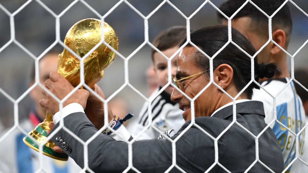 LUSAIL CITY, QATAR - DECEMBER 18: Nusret Goekce, nicknamed Salt Bae, admires the FIFA World Cup Qatar 2022 Winner's Trophy after the FIFA World Cup Qatar 2022 Final match between Argentina and France at Lusail Stadium on December 18, 2022 in Lusail City, Qatar. (Photo by Dan Mullan/Getty Images)