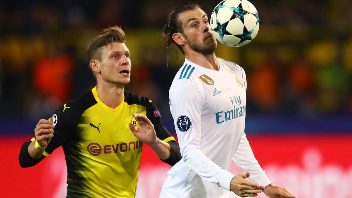 Łukasz Piszczek walczy o piłkę z Garethem Bale'em 