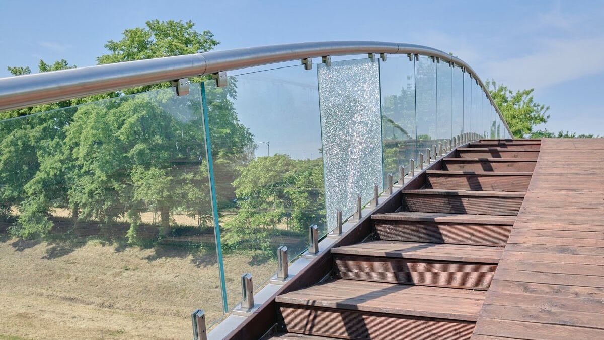 Pęknięta szklana płyta balustrady kładki przy Parku Ludowym