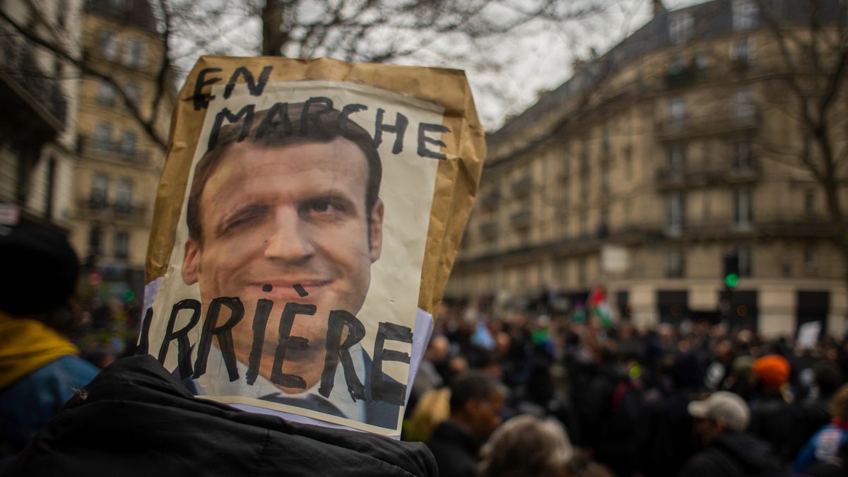 A protestor holds a placard featuring an image of French President Emmanuel Macron during a demonstration against pension reform on Boulevard Voltaire in central Paris, France, on Tuesday, March 28, 2023. French unions are holding a new day of nationwide strikes Tuesday to try to force President Emmanuel Macron to reverse his decision to push through unpopular pension reforms. Photographer: Nathan Laine/Bloomberg via Getty Images