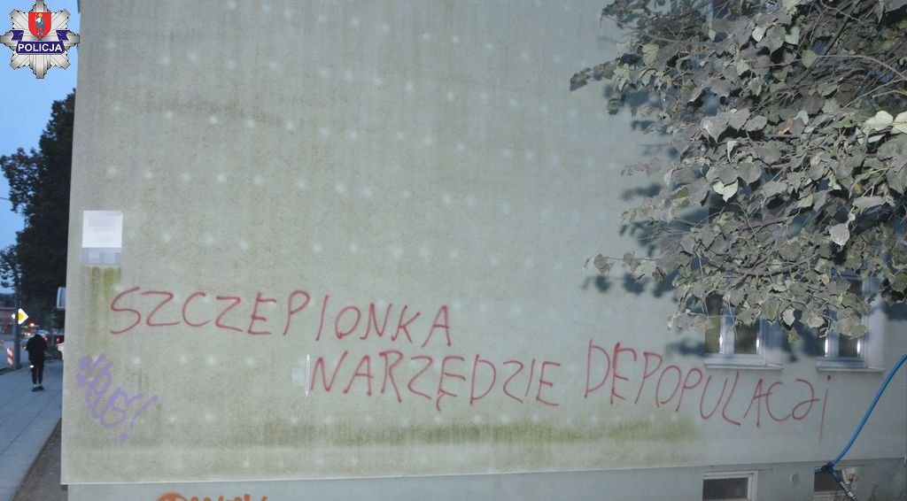 Napis "Szczepionka narzędzie depopulacji" na elewacji budynku