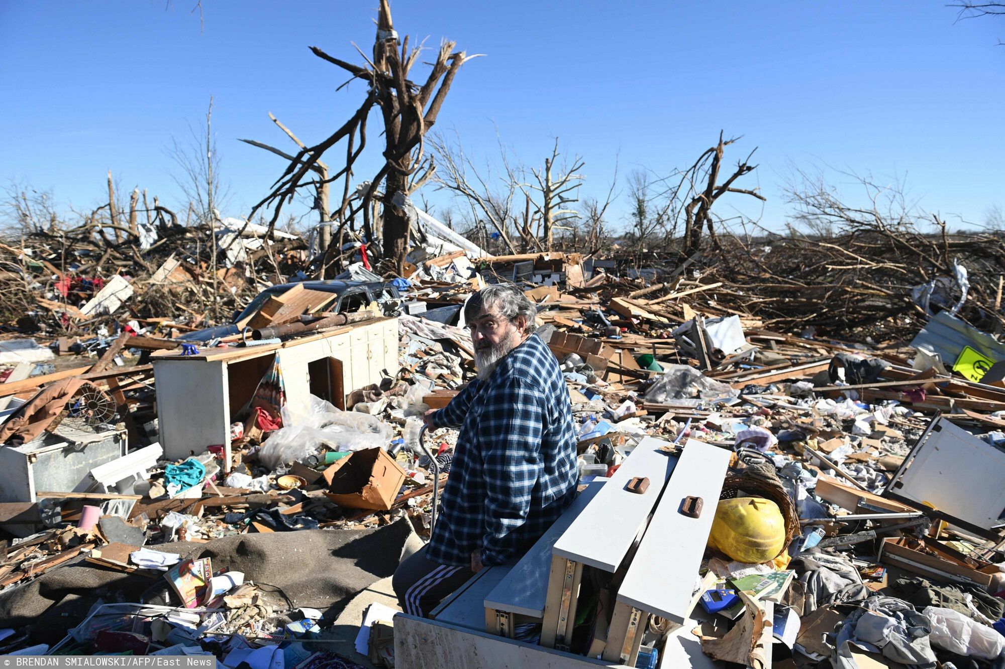 TemporaryBogdan Gaicki surveys tornado damage after extreme weather hit the region December 12, 2021, in Mayfield, Kentucky. - Dozens of devastating tornadoes roared through five US states overnight, leaving more than 80 people dead Saturday in what President Joe Biden said was "one of the largest" storm outbreaks in history. (Photo by Brendan SMIALOWSKI / AFP)BRENDAN SMIALOWSKI