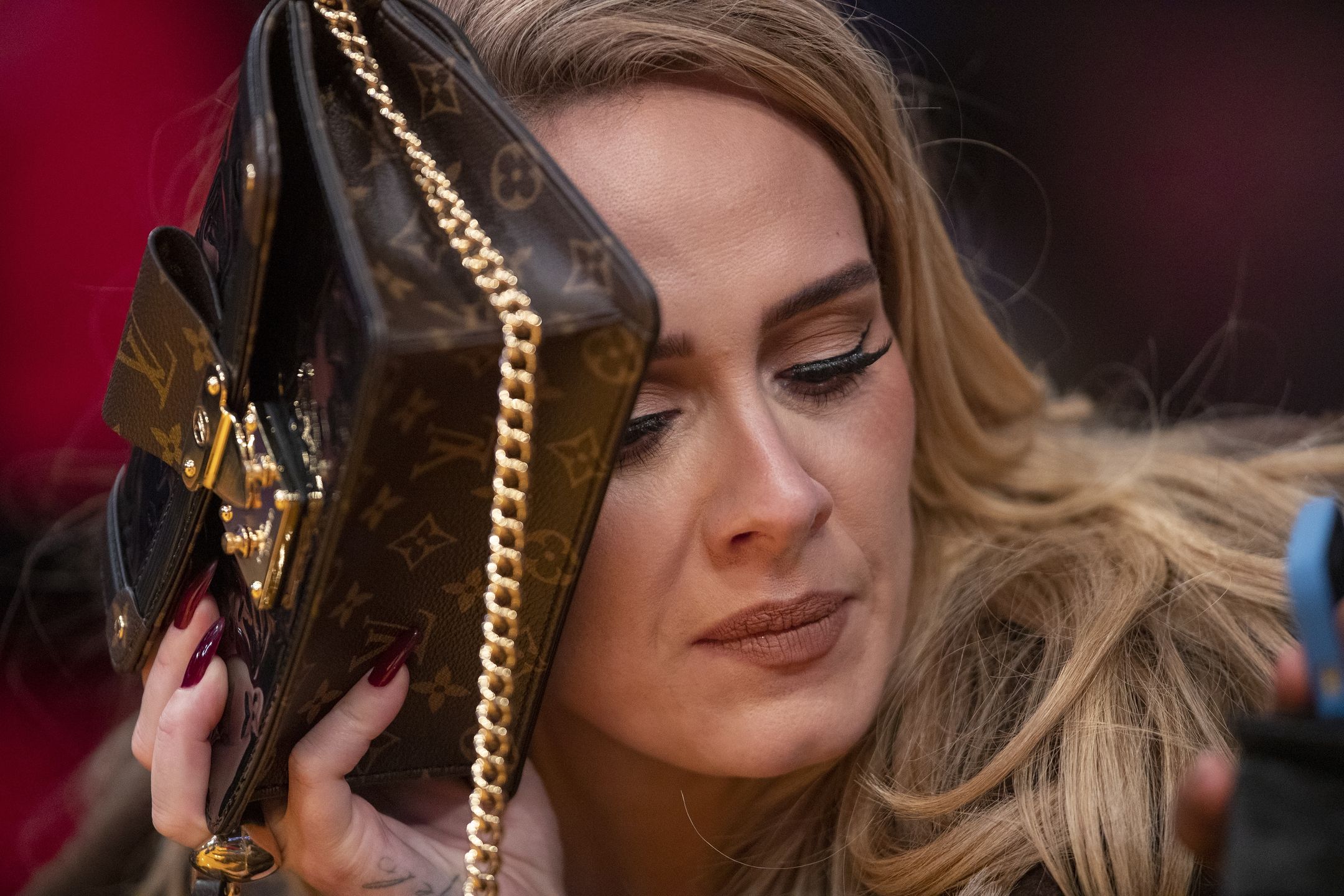 Celebrities attend the Los Angeles Lakers play the Golden State Warriors during the season openerLos Angeles, CA - October 19: Singer Adele uses her purse to hide from the TV camera while she sings along to her song being played to the audience while attending a game between the Golden State Warriors and the Los Angeles Lakers on October 19, 2021 at Staples Center in Los Angeles. (Allen J. Schaben / Los Angeles Times via Getty Images).Allen J. Schabencelebrity, warriors, united states, lakers, los angeles, ca, bestof, topix