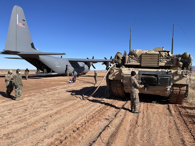 Samolot transportowy C-130 Hercules i czołg M1A2 Abrams połączone wężem paliwowym