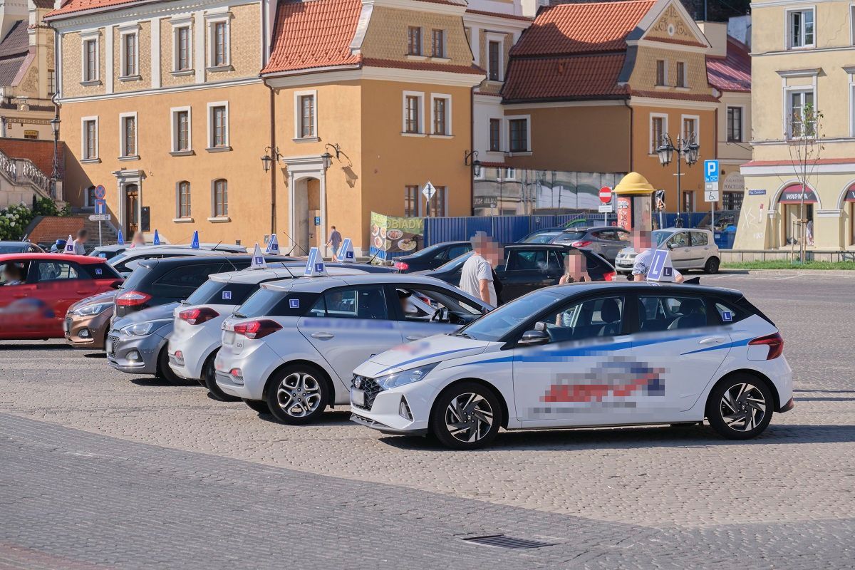 Samochody nauki jazdy blokują miejsca parkingowe na pl. Zamkowym w oczekiwaniu na kursantów