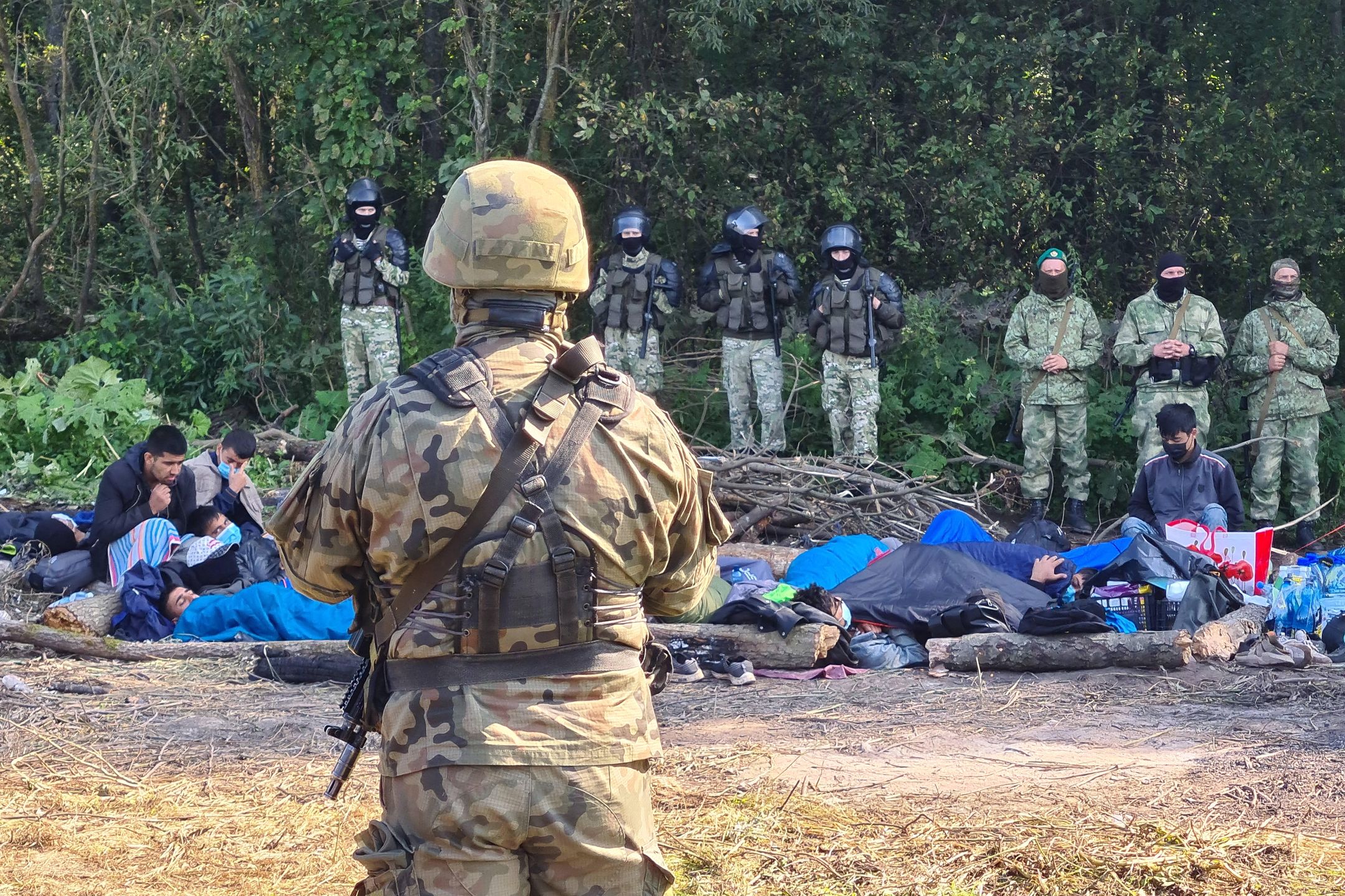 Afghan refugees stranded on Polish-Belarusian borderPODLASIE VOIVODESHIP, POLAND - AUGUST 20, 2021: Armed Polish soldiers and Afghan refugees who have fled the Taliban are seen near the village of Usnarz Gorny in eastern Poland on the border to Belarus. A group of 30 refugees have been stranded at the Polish-Belarusian border under the custody of Polish law enforcement officers for 12 days after illegally crossing the border. Armed members of Belarusian security forces do not let them return to Belarus while Polish border guards and army officers prevent them from continuing their journey across Poland. Irina Polina/TASS 
Dostawca: PAP/ITAR-TASS.Irina PolinaAfghan refugees, Polish border, Polish-Belarusian border, migrants, security, stranded, Poland, Afga�czycy, granica, polsko bia�oruska, polsko-bia�oruska, BINARY<(8) bytes>, wojsko, �o�nierz, �o�nierze