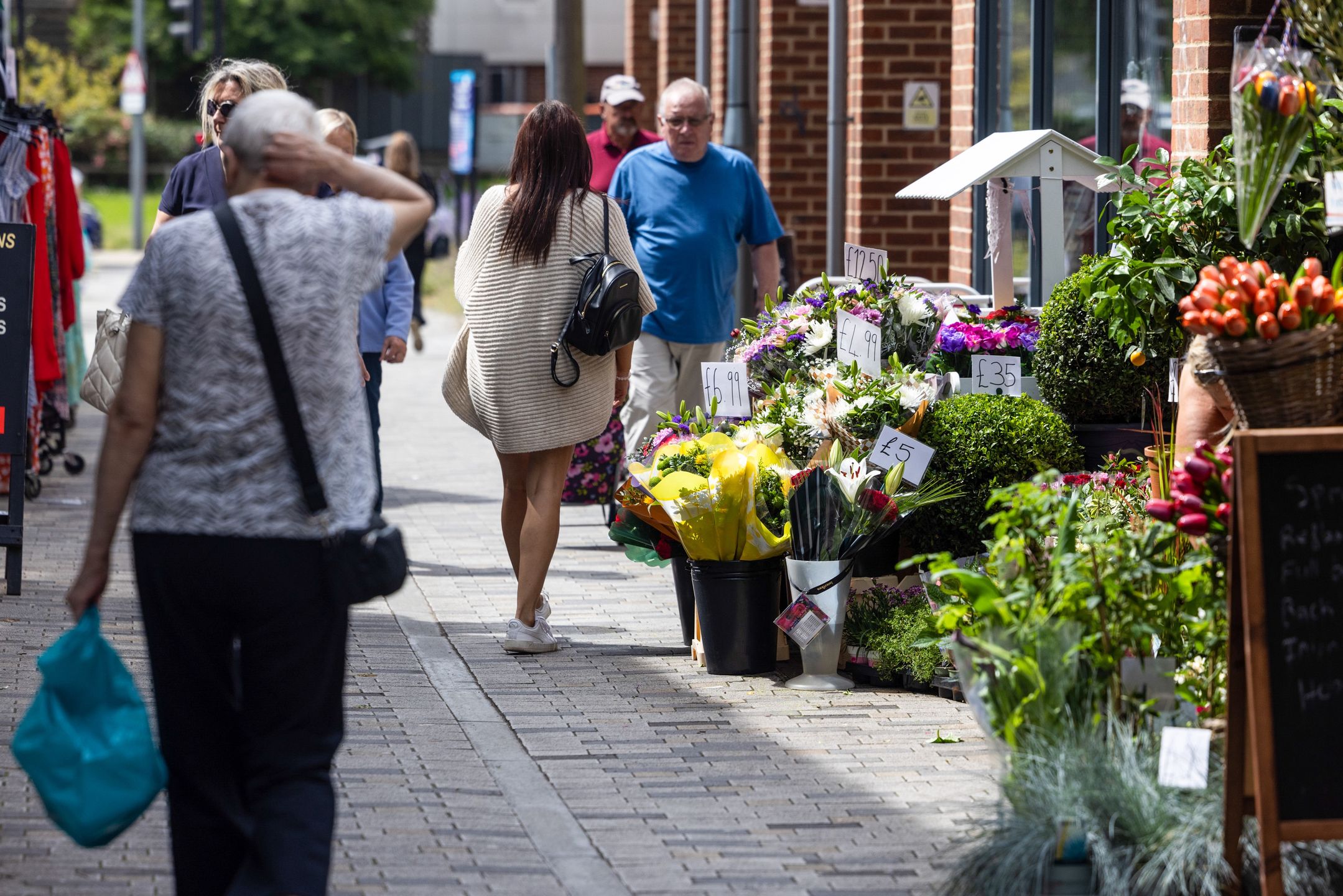 Shoppers pass a flower shop in Strood, UK, on Tuesday, July 16, 2024. Grocery price inflation fell to its lowest level since September 2021 in a further sign of easing cost pressures, ahead of a crucial decision by the Bank of England next month on whether to cut interest rates. Photographer: Chris Ratcliffe/Bloomberg via Getty Images