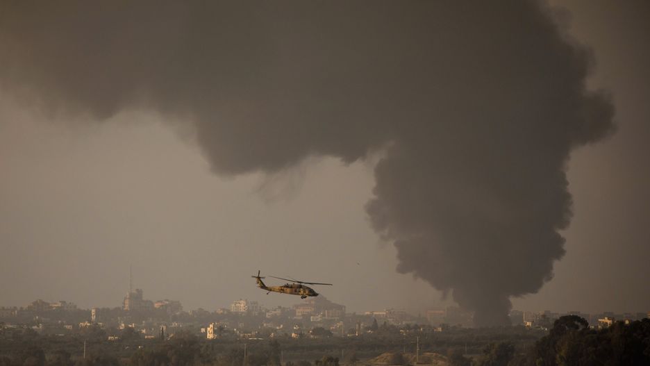 Izraelski helikopter leci wzdłuż granicy. Ze Strefy Gazy unosi się dym
