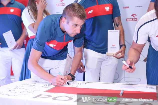 Marcin Lewandowski podpisuje olimpijską flagę