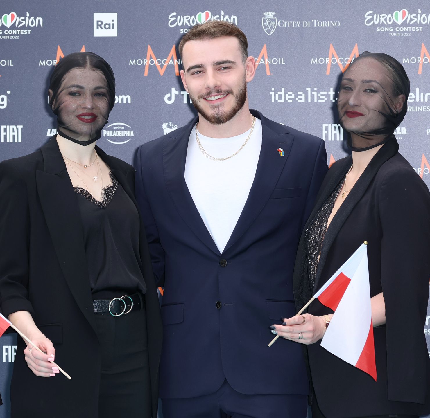 Krystian Ochman pozuje na turkusowym dywanie przed Eurowizją w Turynie