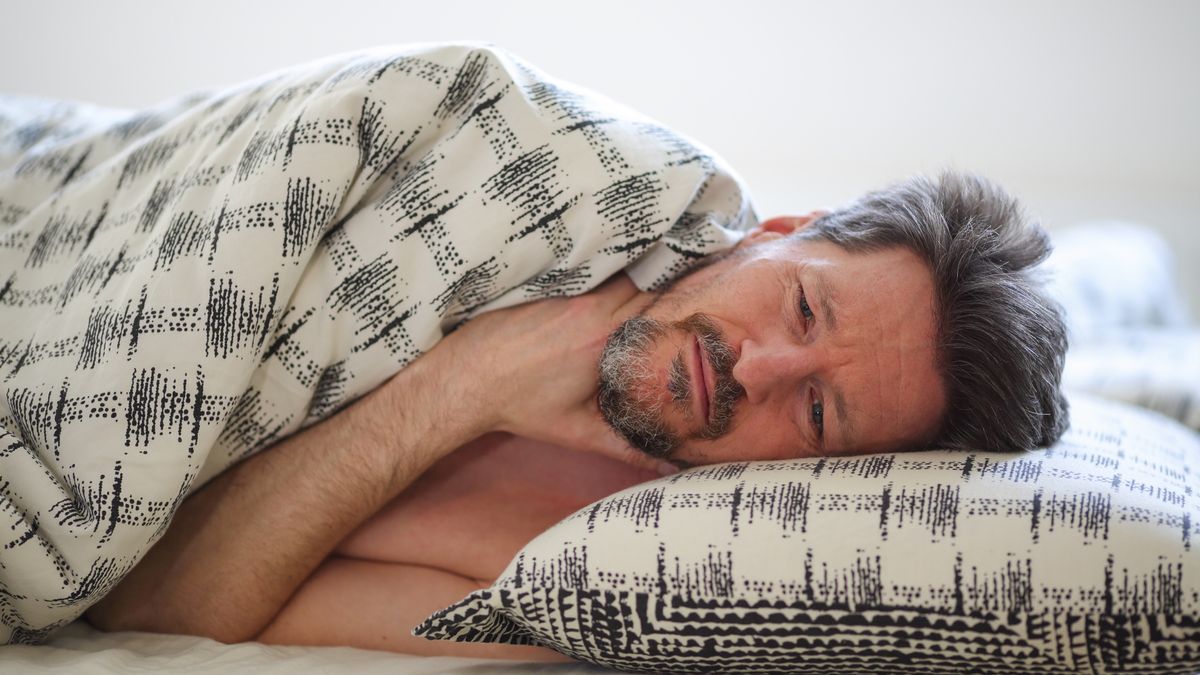 Man with sore throat lying in bed
Mid-adult man with hand on his throat lying in bed in his bedroom.
tomazl