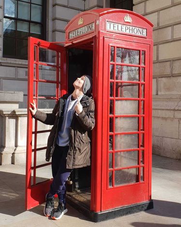 Xavier Wiśniewski pozuje przy budce telefonicznej w Londynie