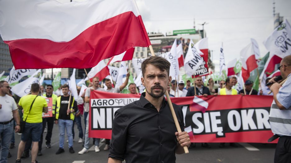 WARSAW, MAZOWIECKIE, POLAND - 2022/07/07: Michal Kolodziejczak, the leader of Agrounia waves the Polish flag during the protest. Organised by AGROunia, farmers marched through the center of Warsaw to parliament protesting the economic crisis and very high costs of agricultural production. They believe that farmers and the poorest inhabitants of the country pay the most for the economic crisis, which they believe was caused by the politicians. Led by charismatic Michal Kolodziejczak, AGROunia is a Polish farmers' organisation that often contest the actions of the Polish government. (Photo by Attila Husejnow/SOPA Images/LightRocket via Getty Images)