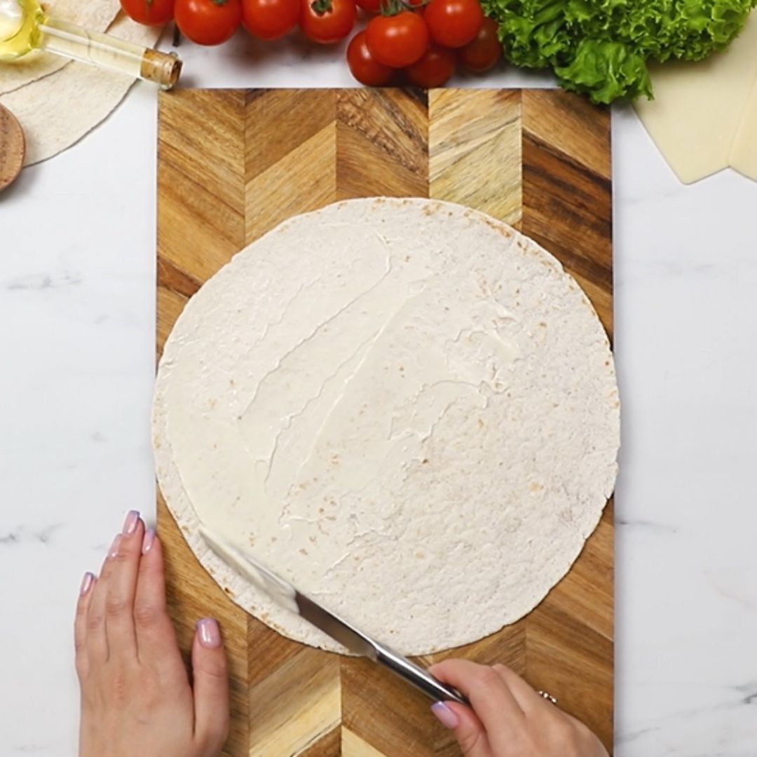 The mayonnaise goes on the tortilla first.