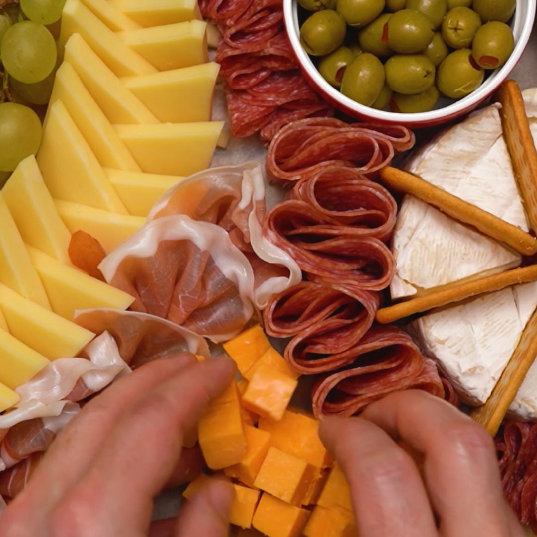 Cheddar kroję w kostkę i układam blisko szynki parmeńskiej