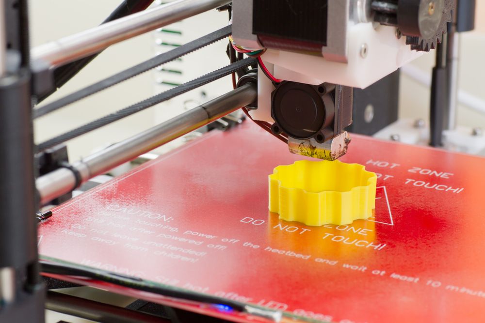 Zdjęcie Detail of a 3D printer printing with a yellow ABS filament pochodzi z serwisu Shutterstock