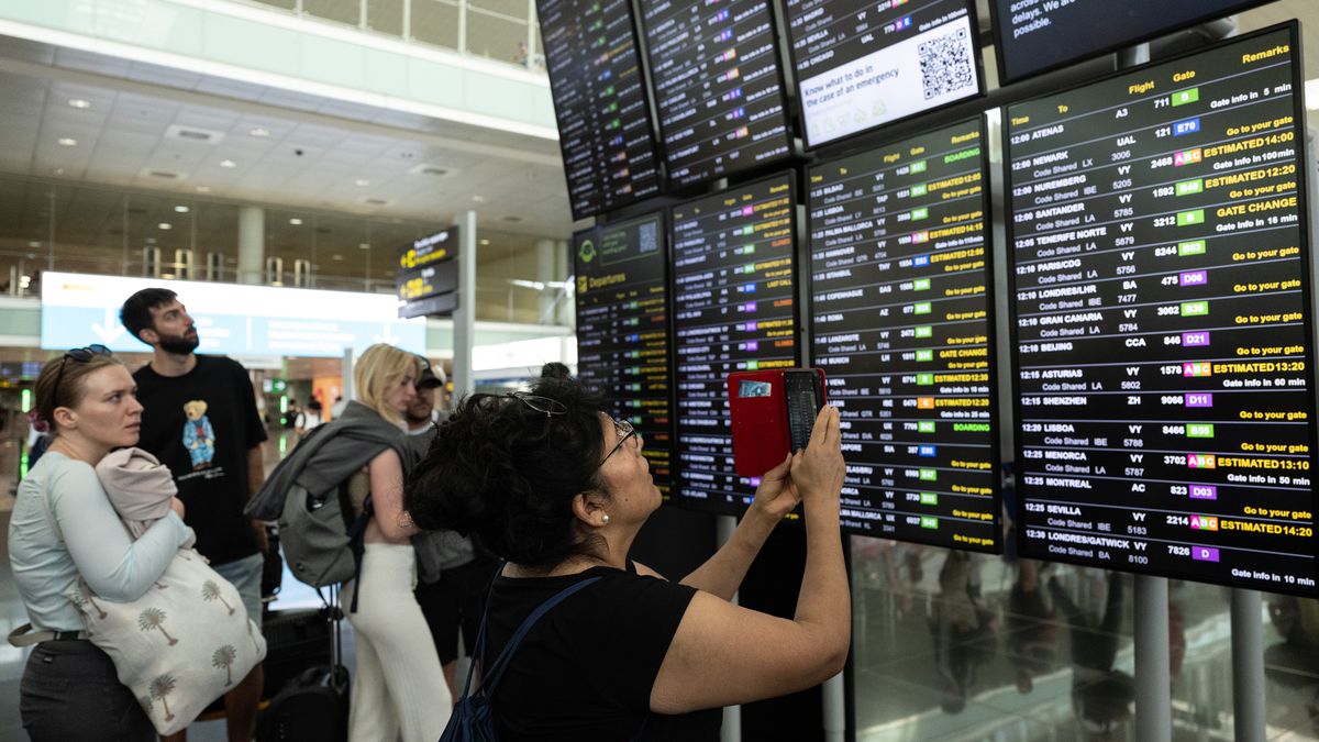 BARCELONA, SPAIN - JULY 19: A passenger takes pictures of a screen displaying delayed flights at Barcelona Aiport on July 19, 2024 in Barcelona, Spain. Businesses, travel companies and Microsoft users across the globe were among those affected by a tech outage today. (Photo by David Ramos/Getty Images)