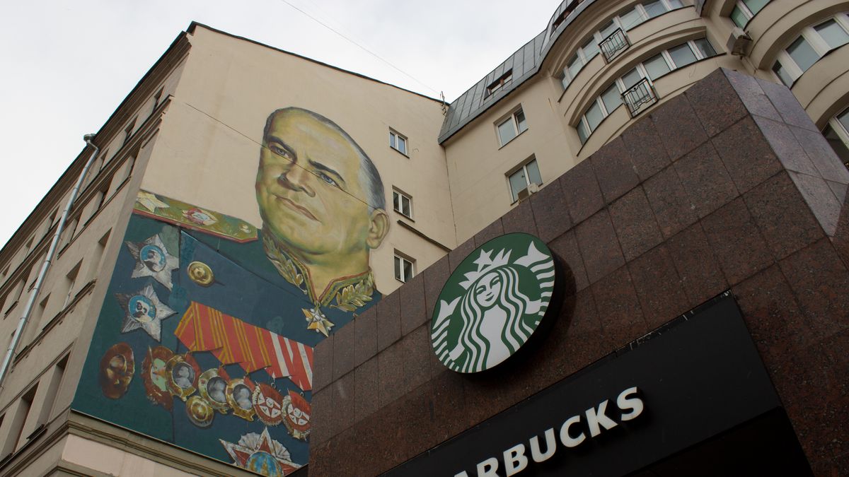 MOSCOW, RUSSIA - 2022/03/27: A Starbucks sign is seen alongside the mural of Georgy Zhukov, a Soviet general and Marshal of the Soviet Union who oversaw some of the USSRâs most decisive victories over Nazi Germany during WWII. (Photo by Vlad Karkov/SOPA Images/LightRocket via Getty Images)