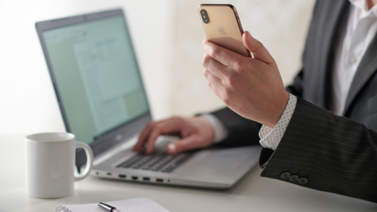 Businessman Using Smartphone And Laptop
Close up detail of a businessman working at a desk with a smartphone and laptop computer, taken on January 31, 2019. (Photo by Neil Godwin/Future via Getty Images)
Future Publishing
Colour Image, Color Image, Horizontal, Photography, Indoors, Adults Only, One Person, People, Male, Men, One Man Only, Mid Section, Part Of, Hand, Human Hand, Sitting, Typing, Formal Clothing, Businesswear, Button Down Shirt, White Shirt, Suit Jacket, Smart Casual, Technology, Wireless Technology, Hardware, Computer, Laptop, Using Laptop, Dell Inspiron, Accessibility, Portability, Communication, Phone, Mobile Phone, Portable Information Device, Smart Phone, Smartphone, Telephone, Apple iPhone XS, Messaging, The Internet, Mug, Cup, Hot Drink, Coffee, Notebook, Notepad, Pen, Desk, Business, Occupation, Professional, Work, Working, Business Finance and Industry, Place Of Work, Productivity, Lifestyles, Copy Space, Business Person, Businessman