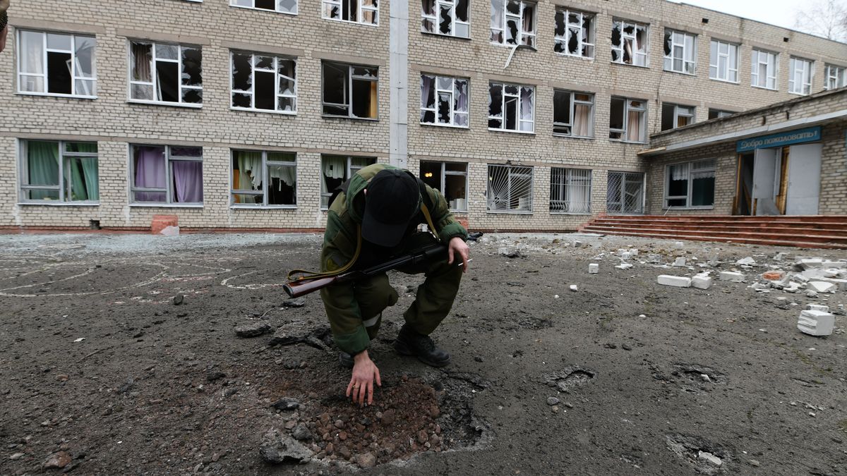 DONETSK, UKRAINE - FEBRUARY 25: A man looks at a hole in the ground in front of a destroyed school after it was allegedly targeted by Ukraine in Horlivka (Gorlovka) city of Donetsk region under the control of pro-Russian separatists, Ukraine on February 25, 2022. (Photo by Stringer/Anadolu Agency via Getty Images)