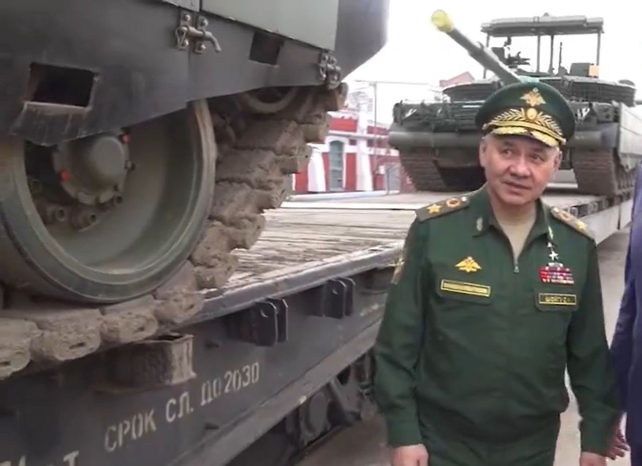 Siergiej Szojgu na tle czołgów T-80BWM