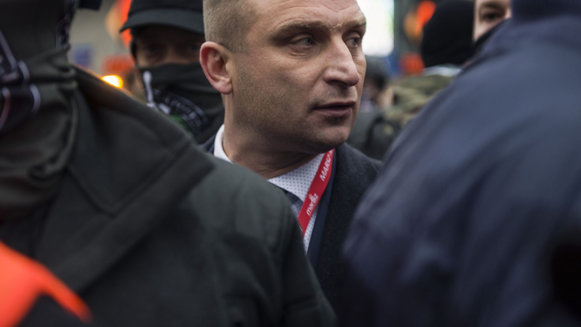 WARSAW, POLAND - 2020/11/11: Robert Bakiewicz, president of the Independence March Association looking on with his bodyguards during Independence Day.Thousands took part in an annual far-right march in Warsaw to mark Polands Independence Day, defying coronavirus restrictions. An apartment next to the Poniatowski Bridge was set on fire allegedly for being decorated with rainbow flags and Womens Strike banners. This year's Independence Day March was planned in a motorised formula. (Photo by Attila Husejnow/SOPA Images/LightRocket via Getty Images)