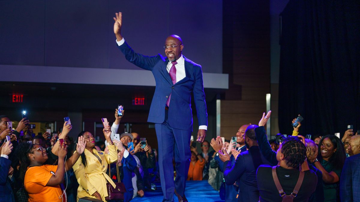 Na zdjęciu Raphael Warnock machający do swoich wyborców z podestu