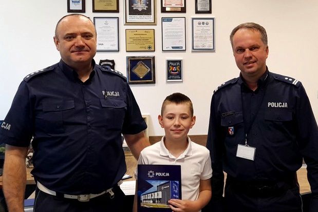 Chłopiec odbiera podziękowania od Komendanta Policji.