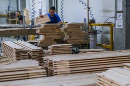 WAGROWIEC, POLAND - DECEMBER 11: A worker chooses pieces of wood for a machine to assemble coffins inside the Lindner coffin maker factory on December 11, 2020 in Wagrowiec, Poland. The company, Poland's largest coffin maker and exporter for Western Europe (Germany, Netherlands, Denmark, Belgium, France, UK) who produces an average of 16000 coffins a month, reported a 2-percent rise in production over the previous year.  During the first wave of the coronavirus, Lindner reports a disruption on the annual rhythm of the business. Customers were afraid of closing the borders in March and it was also difficult for them to estimate how many coffins they would need, so they ordered "in advance". As increasing the production in a few days is not possible due to logistics, the waiting time for delivery of coffins increased from 3 to 8 weeks. It should also be noted that this year, customers ordered more cheaper coffins often used for cremation. Lindner, apart of being a role model of Polish coffin makers, also contributes for cultural events in the region, publishes his annual calendar merging the coffin business with artistic fashion photoshoots and develops ecologic paths for a more sustainable path for the industry. (Photo by Omar Marques/Getty Images)
