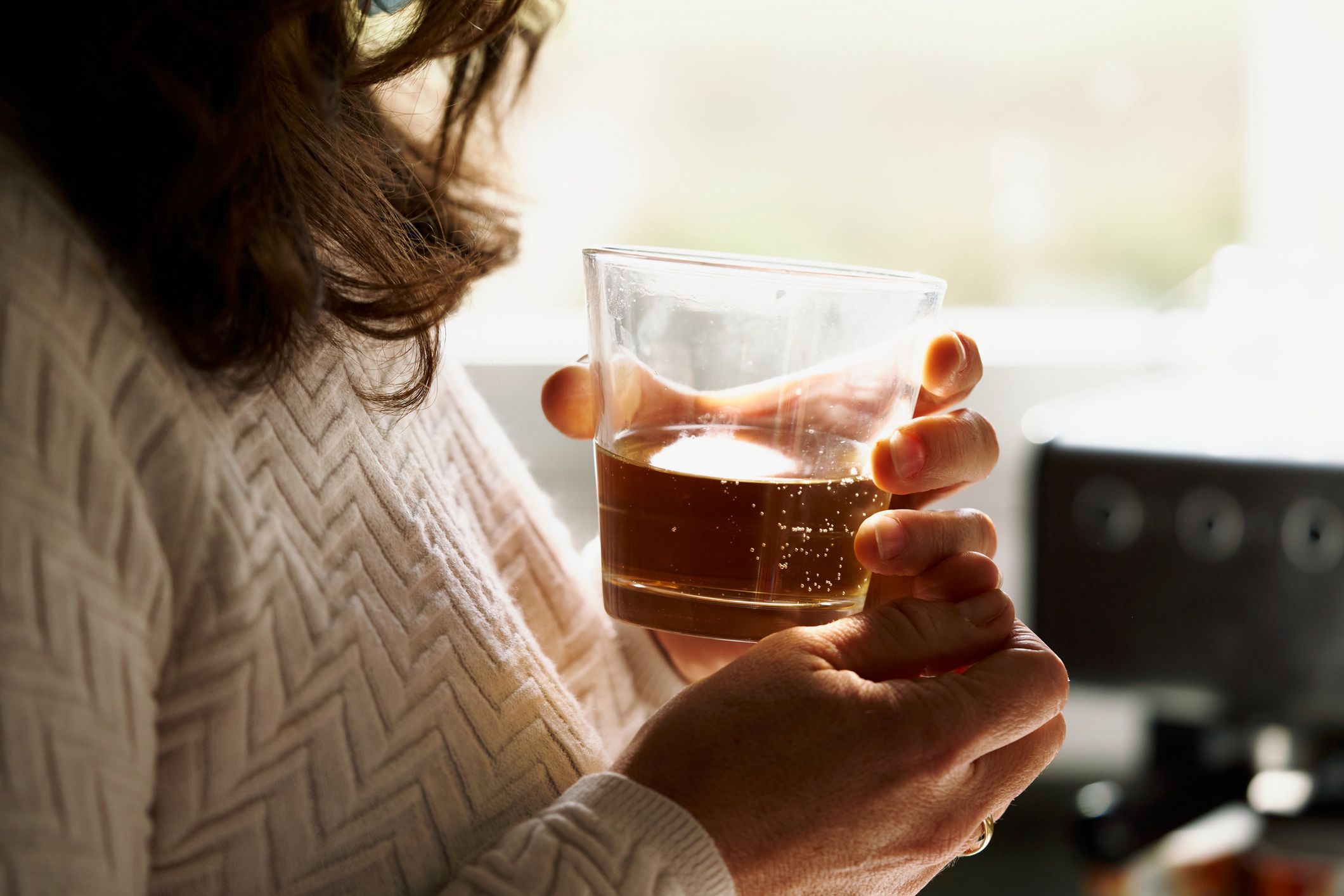 glass cup between hands woman with a glass of whiskey in her hands in front of a windowglass cup between hands woman with a glass of whiskey in her hands in front of a windowaire images