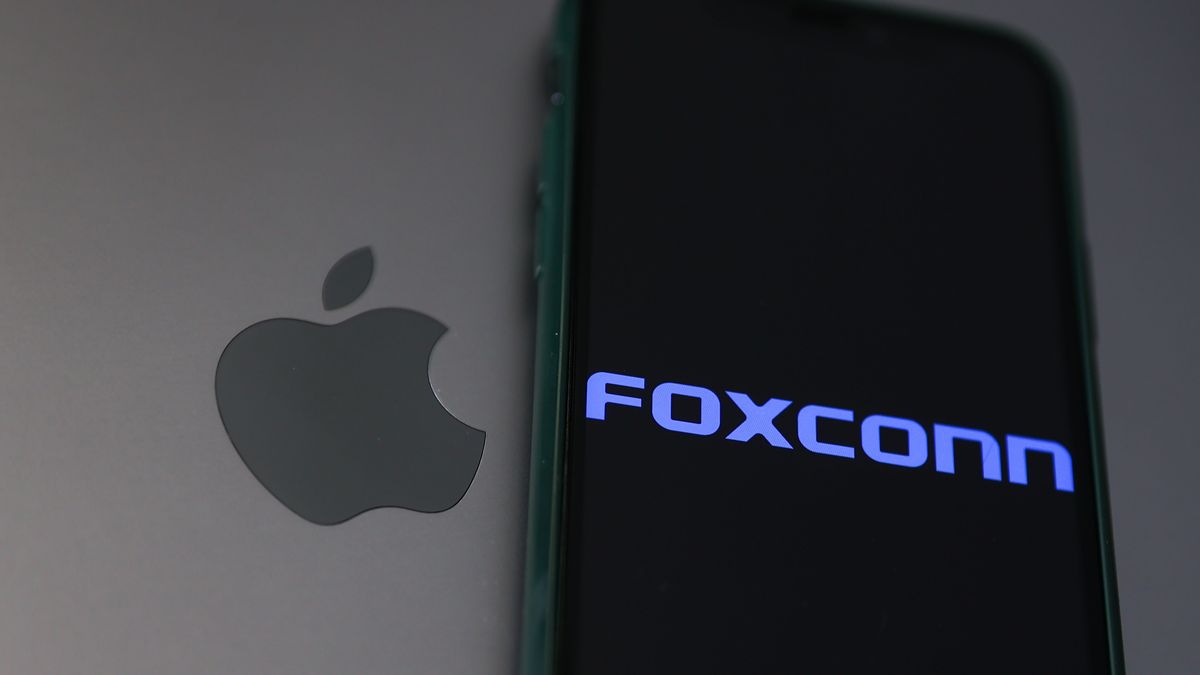 Foxconn logo displayed on a phone screen and Apple logo on a laptop are seen in this illustration photo taken in Krakow, Poland on November 2, 2022. (Photo by Jakub Porzycki/NurPhoto via Getty Images)