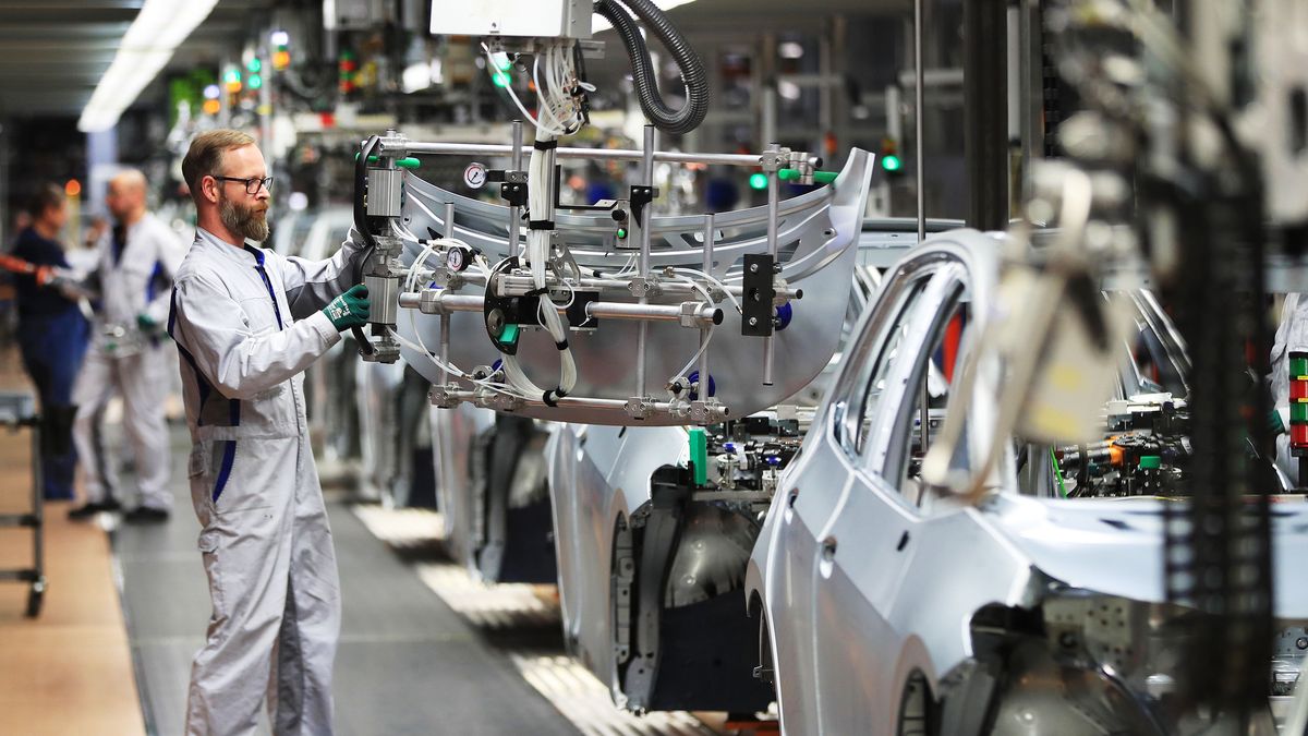 A employee uses a winch to fit a trunk panel to a Volkswagen AG (VW) ID.3 electric automobile at the automaker's assembly line in Zwickau, Germany, on Tuesday, Feb. 25, 20120. The worlds largest automaker plans to eliminate carbon dioxide emissions by 2050 and will invest 33 billion euros through 2024 to build the industrys biggest fleet of electric cars. Photographer: Krisztian Bocsi/Bloomberg via Getty Images