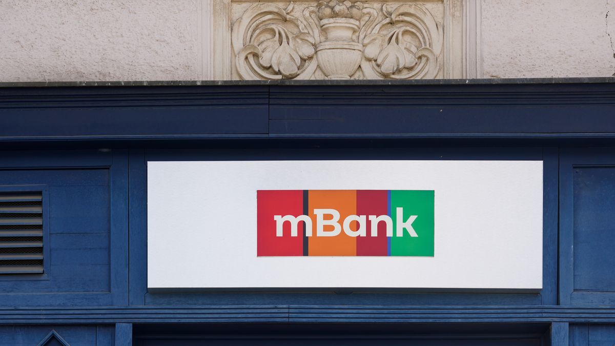 The logo of the Polish bank mBank appears on a white signboard with red, orange, and green color blocks above the branch entrance in Prague, Czech Republic, on May 11, 2025. mBank is a Polish financial institution that also operates branches in the Czech Republic, offering digital banking and financial services. (Photo by Michael Nguyen/NurPhoto via Getty Images)