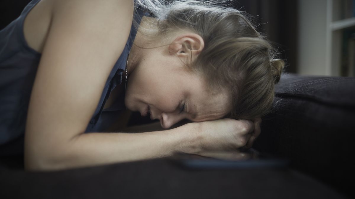 Sad young woman lying on couchOliver RossiLeisure, Domestic Life, Pain, Sadness, Worries