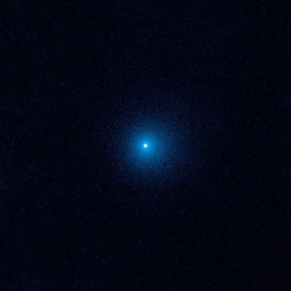 To zdjęcie z Kosmicznego Teleskopu Hubble’a pokazuje rozmyty obłok pyłu, zwany komą, otaczający kometę C/2017 K2 PANSTARRS (K2), najdalszą aktywną kometę kiedykolwiek zaobserwowaną, wchodzącą do Układu Słonecznego. Hubble wykonał zdjęcia K2, gdy zamarznięty gość znajdował się ponad 2,4 miliarda kilometrów od Słońca, tuż za orbitą Saturna. Nawet z tej odległej odległości światło słoneczne ogrzewa mroźną kometę, wytwarzając komę o szerokości 128 000 kilometrów, która otacza maleńkie, stałe jądro. K2 podróżuje od milionów lat ze swojego domu w Obłoku Oorta, sferycznym regionie na skraju naszego Układu Słonecznego. Ten mroźny obszar zawiera setki miliardów komet, lodowych pozostałości po powstaniu Układu Słonecznego 4,6 miliarda lat temu. Zdjęcie zostało zrobione w czerwcu 2017 roku przez szerokokątną kamerę Hubble’a 3