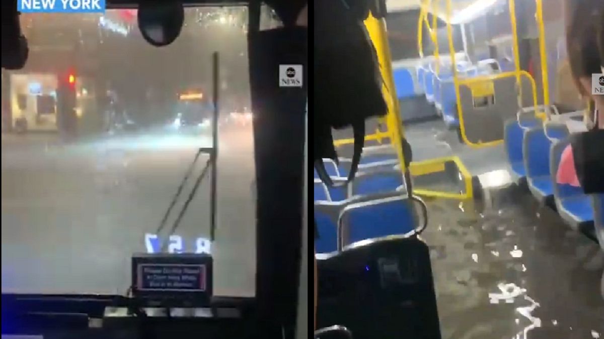 Zalany autobus i pasażerowie stojący na siedzeniach