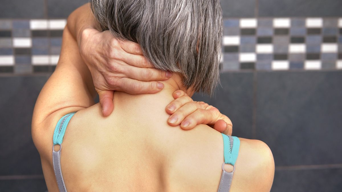 woman rubbing back of neckwoman in pain rubbing neckPeter Dazeleygrey hair, spinal injury, back pain, unwell, poor posture, injury