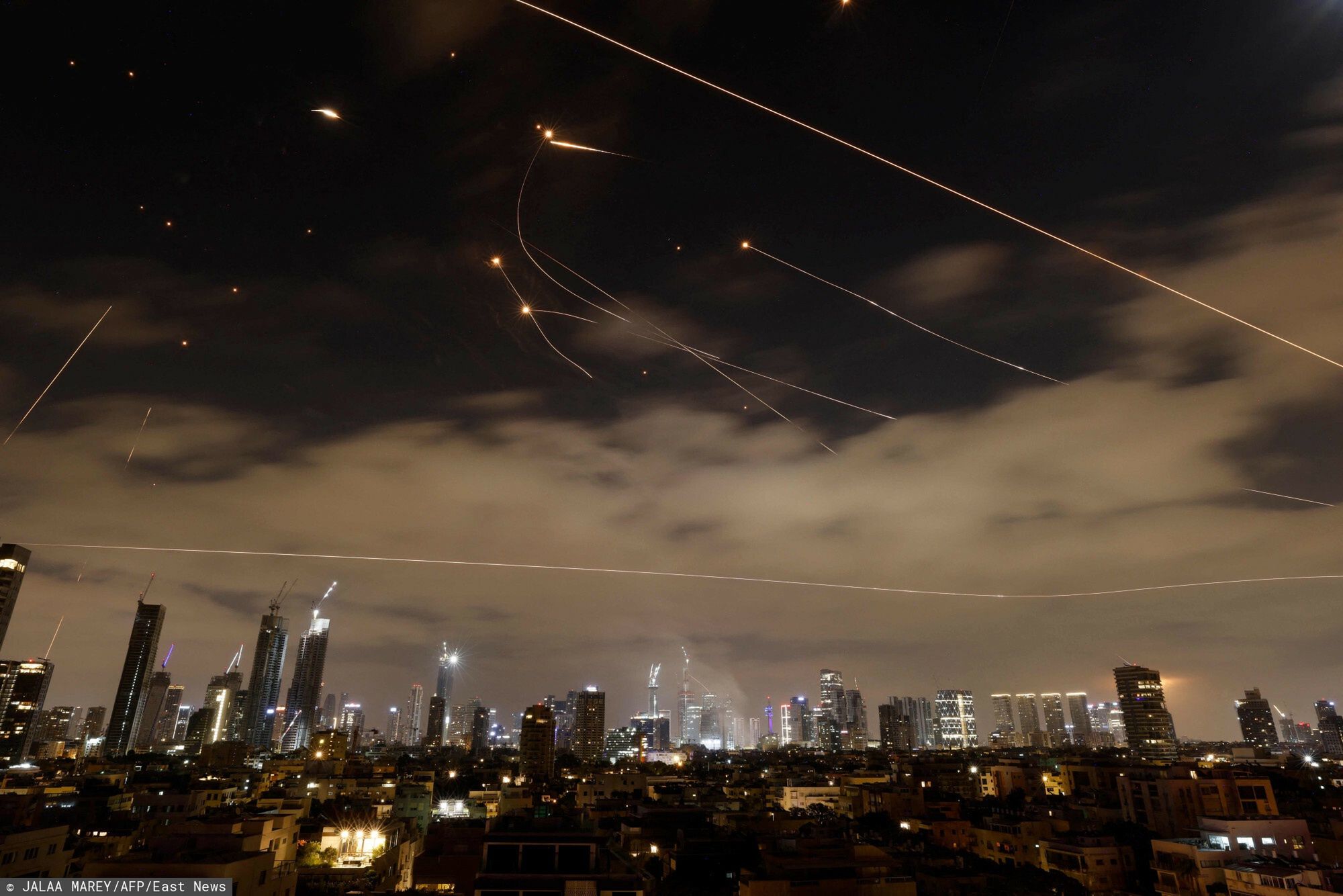 Konflikt Izraela z Iranem
Israeli air defence systems are activated to intercept Iranian missiles over the Israeli city of Tel Aviv amid a fresh barrage of Iranian rockets on June 16, 2025. The Israeli military said early on June 16 that it was striking surface-to-surface missile sites in Iran, its latest move in three days of escalating conflict between the rival states. "The IDF is currently striking surface-to-surface missile sites in central Iran," Israel Defense Forces (IDF) spokesman Nadav Shoshani wrote on X. "We are operating against this threat in our skies and in Iranian skies." (Photo by Jalaa MAREY / AFP)
JALAA MAREY