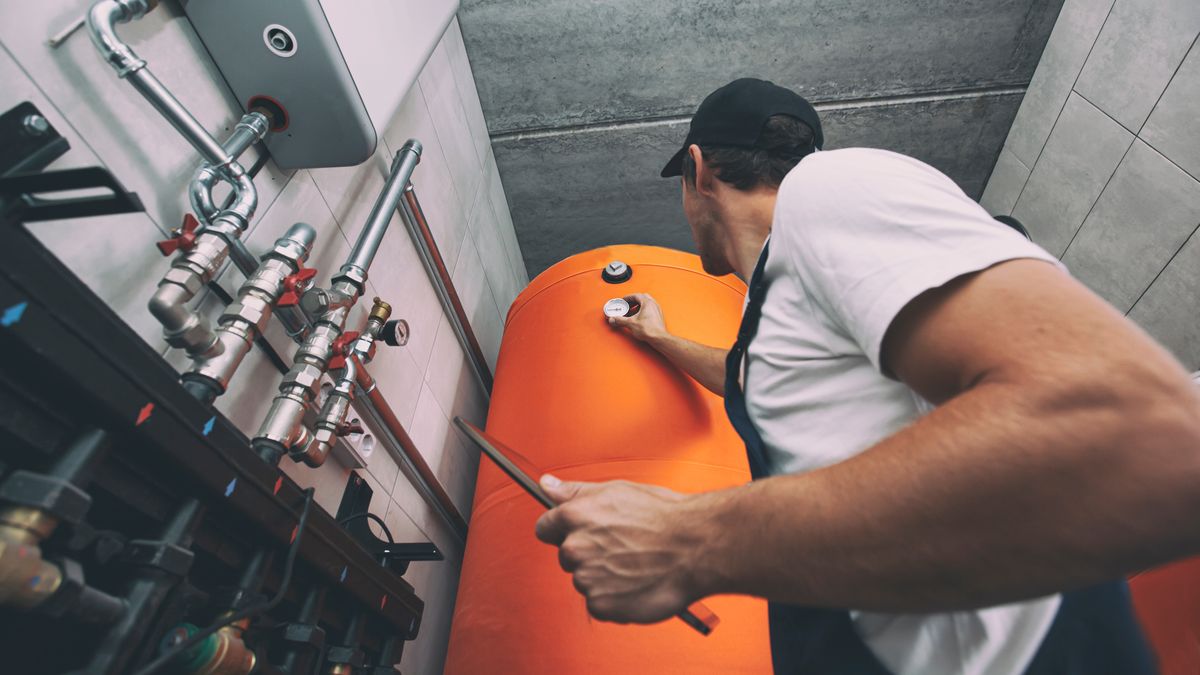 The technician checking the heating system in the boiler room with tablet in handplumbing, heater, repairing, check, home, house, install, inspection, plant, uniform, heat, control, operator, heating, factory, engineering, contractor, serviceman, fixing, controlling, installing, service, valve, tablet, plumber, work, engineer, maintenance, technology, water, industry, pipe, worker, repairman, equipment, technician, inspector, checking, repair, occupation, job, professional, fix, boiler, safety, man, pump, pipes, industrial, system
