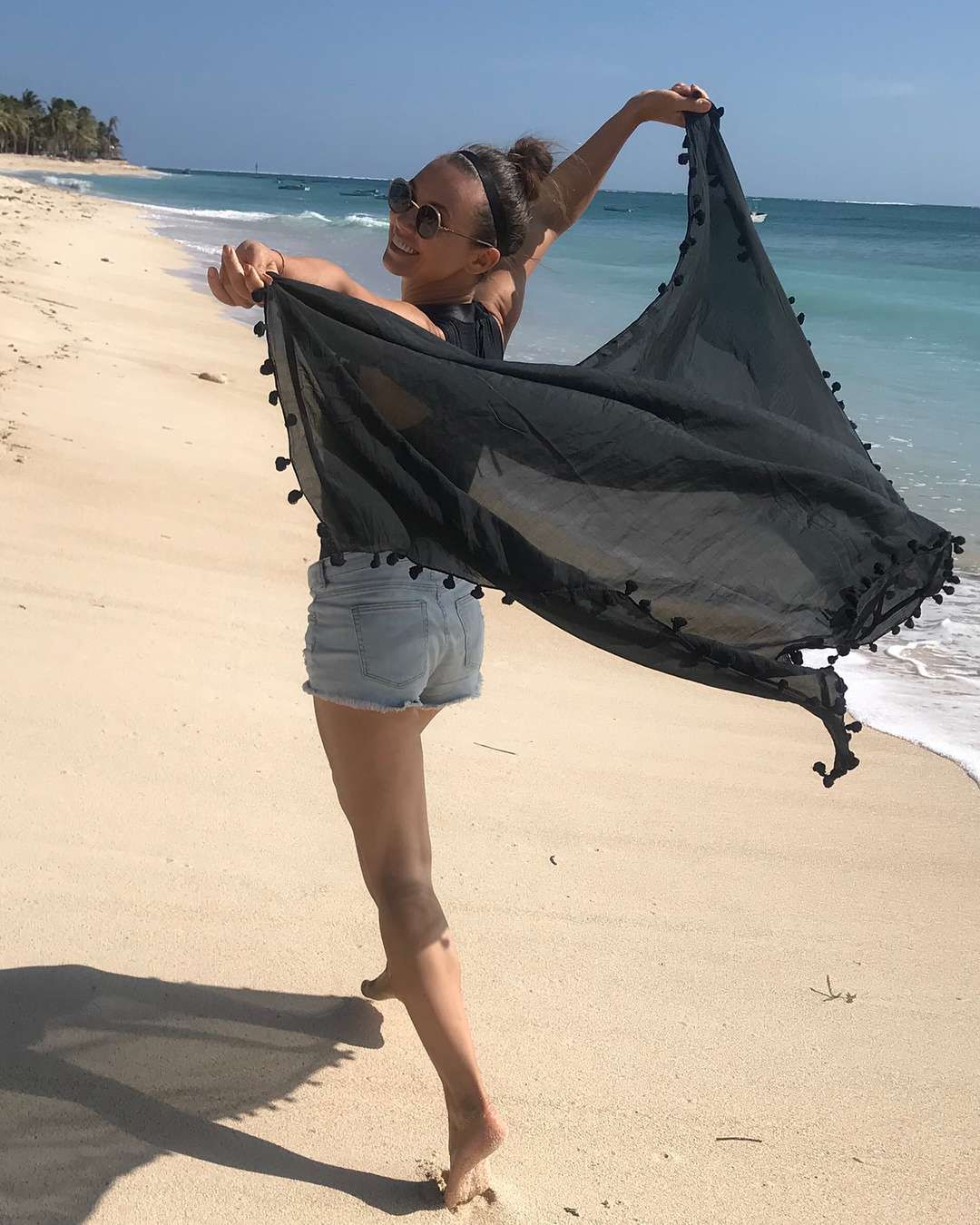 Kinga Rusin biega z czarną chustą po plaży