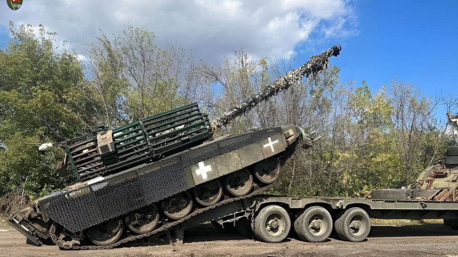 Ukraińska załoga ściąga z transportera kołowego czołg T-72B3 przejęty od Rosjan.