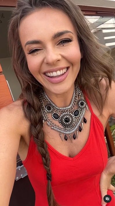 Edyta Herbuś w czerwonym stroju pląsa po tarasie