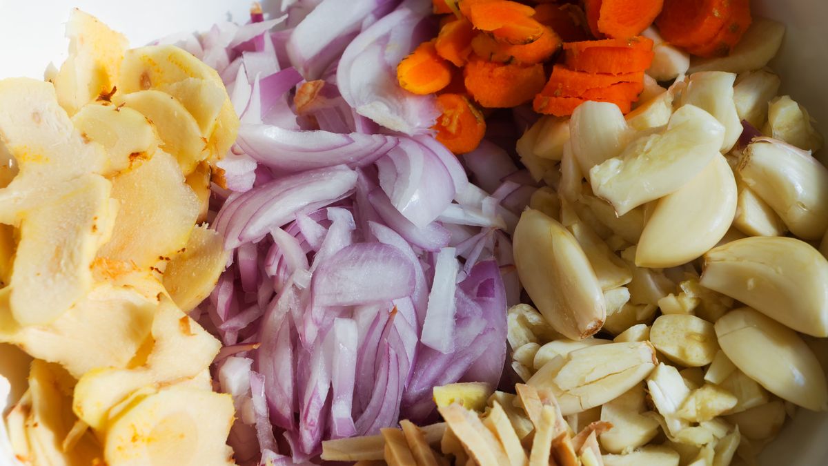 Chopped fresh turmeric, onion, ginger, galangal and garlicClose-up shot of cut fresh turmeric, onion, ginger, galangal and garlic inside bowl. Ingredient for making Chili paste or 'Sambal Cili'photograph by dorisj