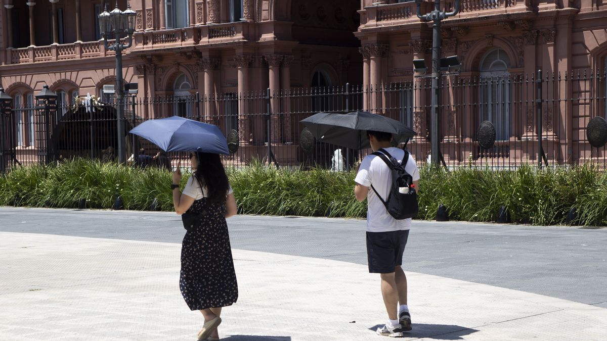 Two people hold umbrellas to protect themselves from the sun in front of the Casa Rosada in Buenos Aires, Argentina, on a day of high temperatures. (Photo by Silvana Safenreiter/NurPhoto via Getty Images)