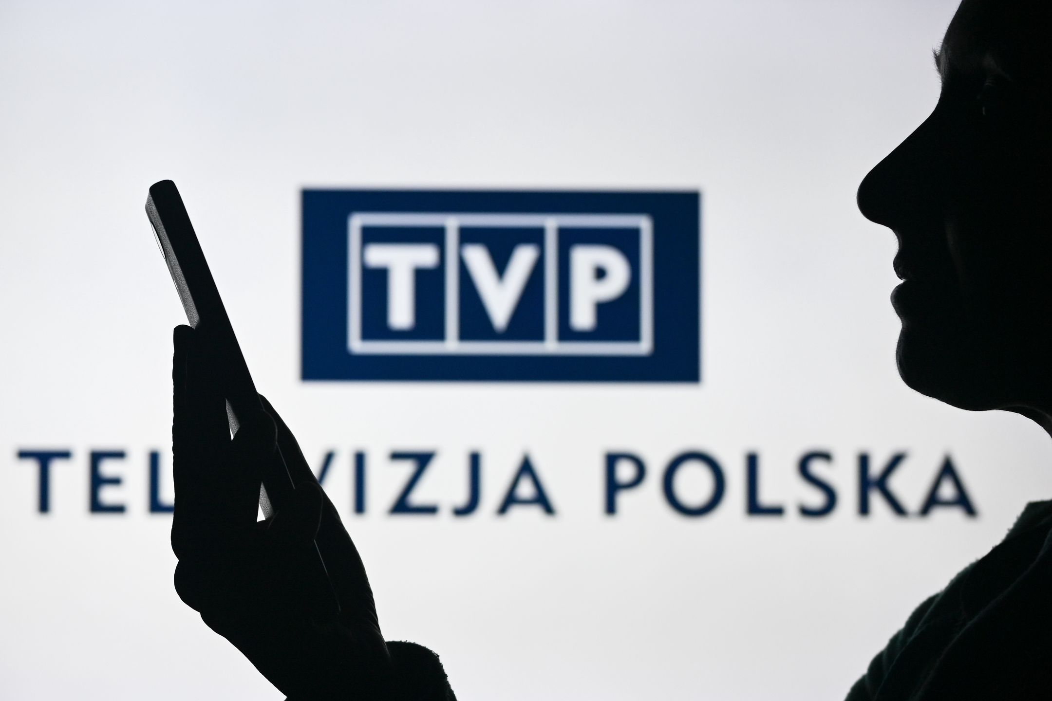 EDMONTON, CANADA - APRIL 28:
An image of a woman holding a cell phone in front of the TVP - Telewizja Polska media company logo displayed on a computer screen, on April 29, 2024, in Edmonton, Canada. (Photo by Artur Widak/NurPhoto via Getty Images)