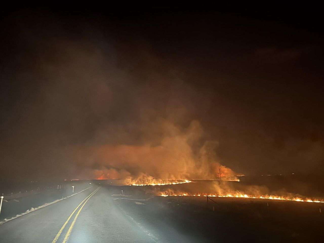 TEXAS PANHANDLE - FEBRUARY 27:  In this handout photo provided by the Texas A&M Forest Service, fire crosses a road in the Smokehouse Creek fire on the evening of February 27, 2024 in the Texas panhandle. The blaze has grown to more than 850,000 acres since igniting Monday, making it the second largest wildfire in Texas state history.  (Photo by Texas A&M Forest Service via Getty Images)