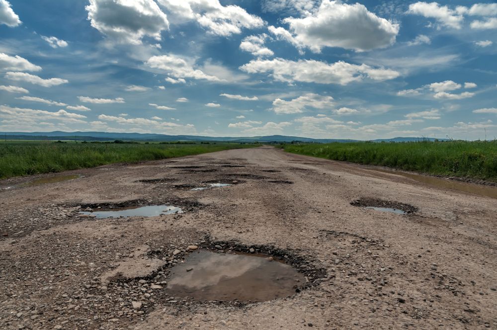 Zdjęcie drogi z dziurami pochodzi z serwisu shutterstock.com